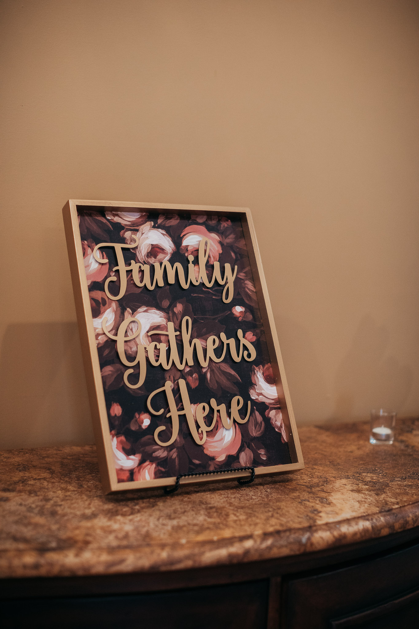 A picture frame with the words family gathers here on it.