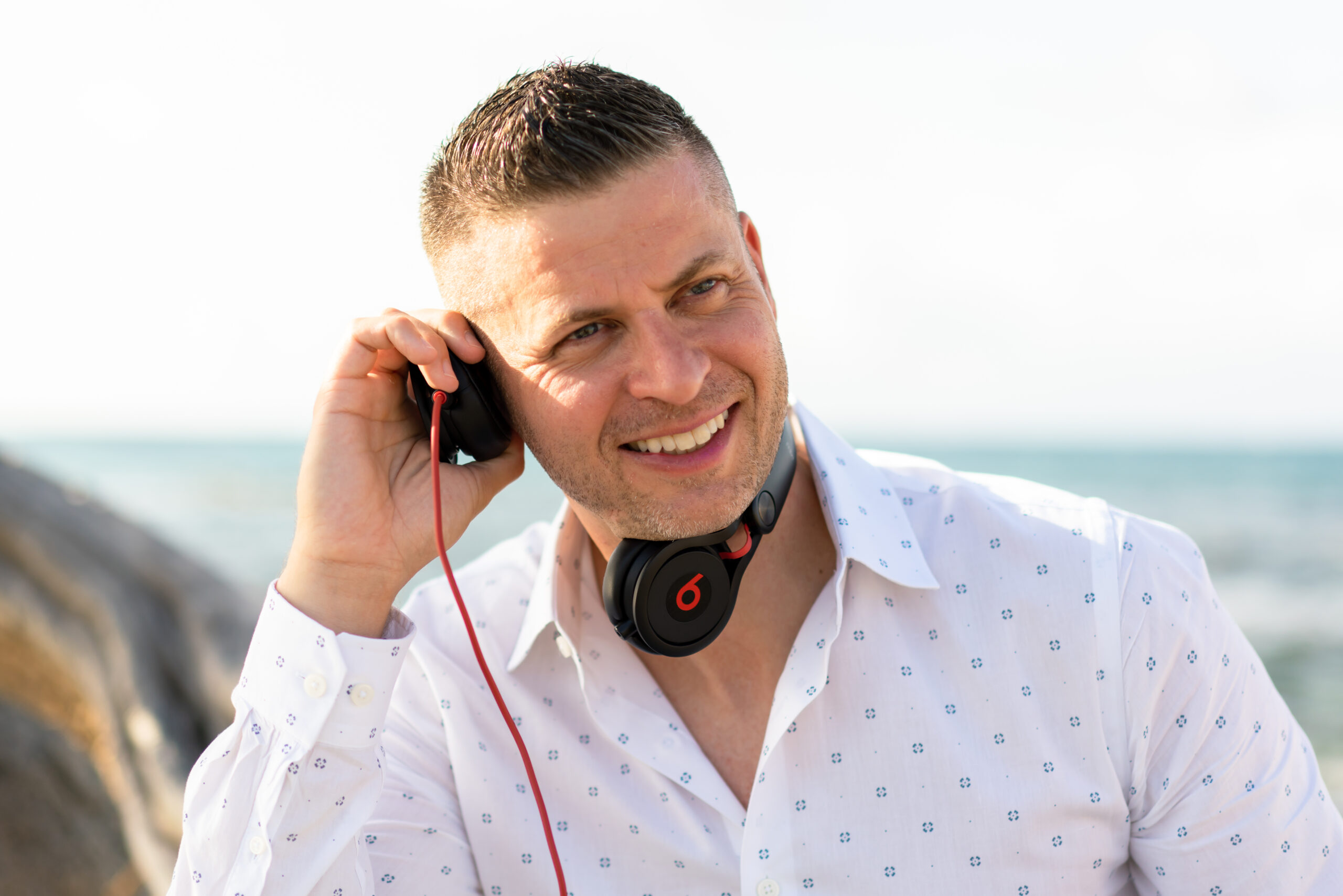 A man with headphones on smiling for the camera.