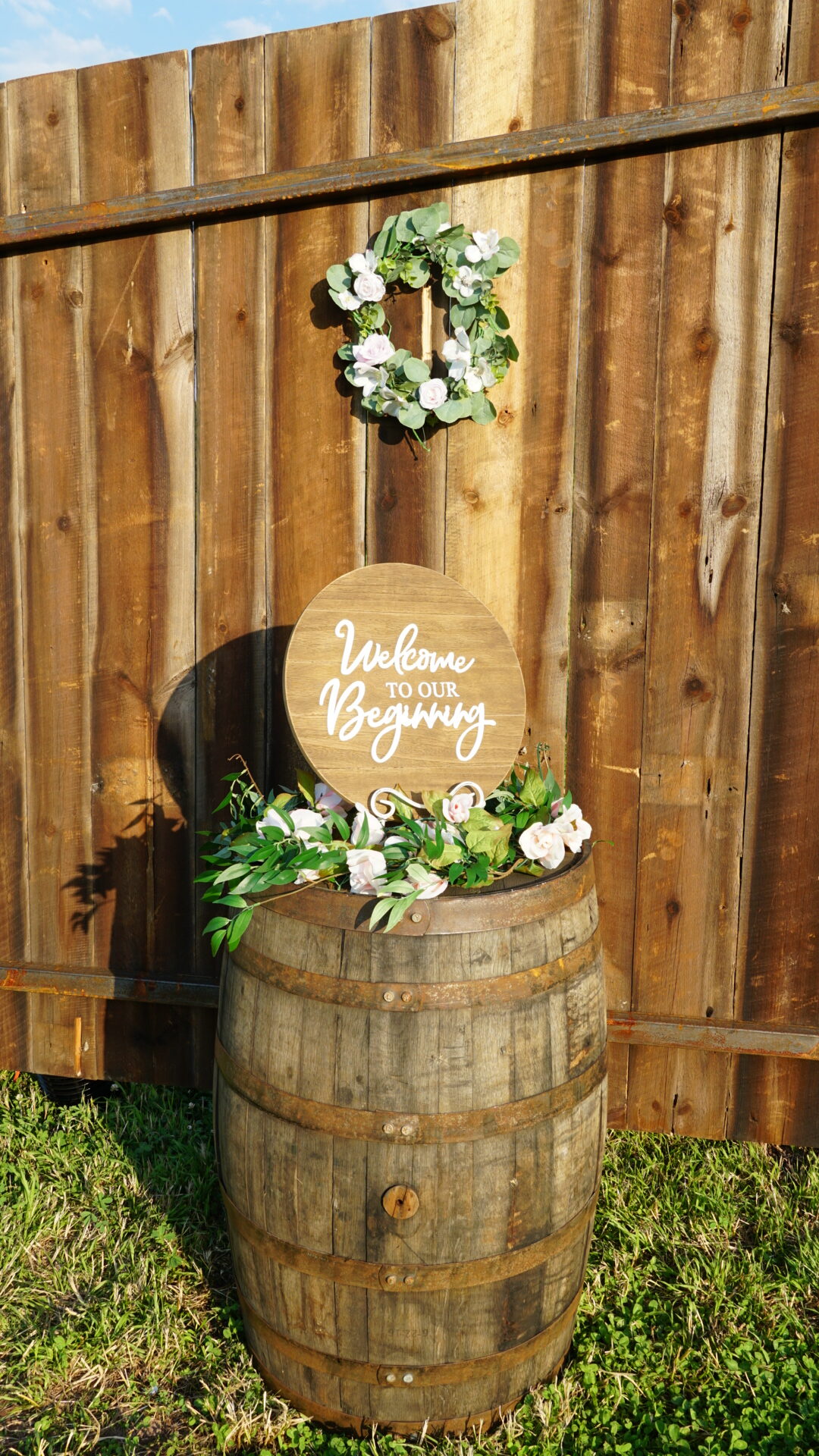 A wooden barrel with flowers on top of it.