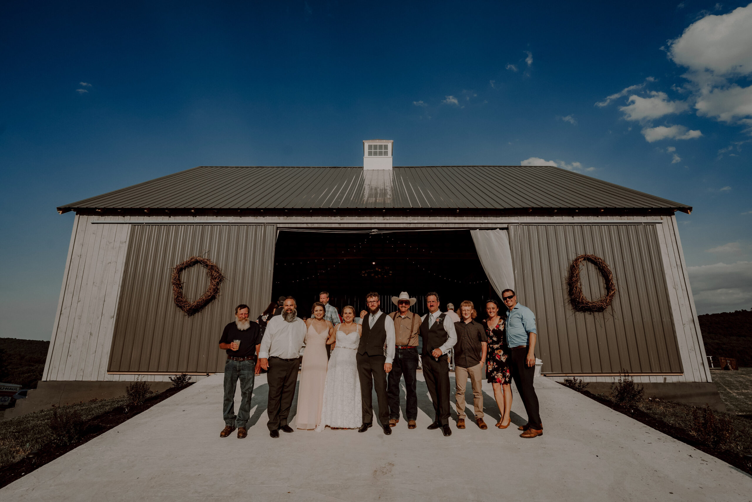 A group of people standing in front of a barn.